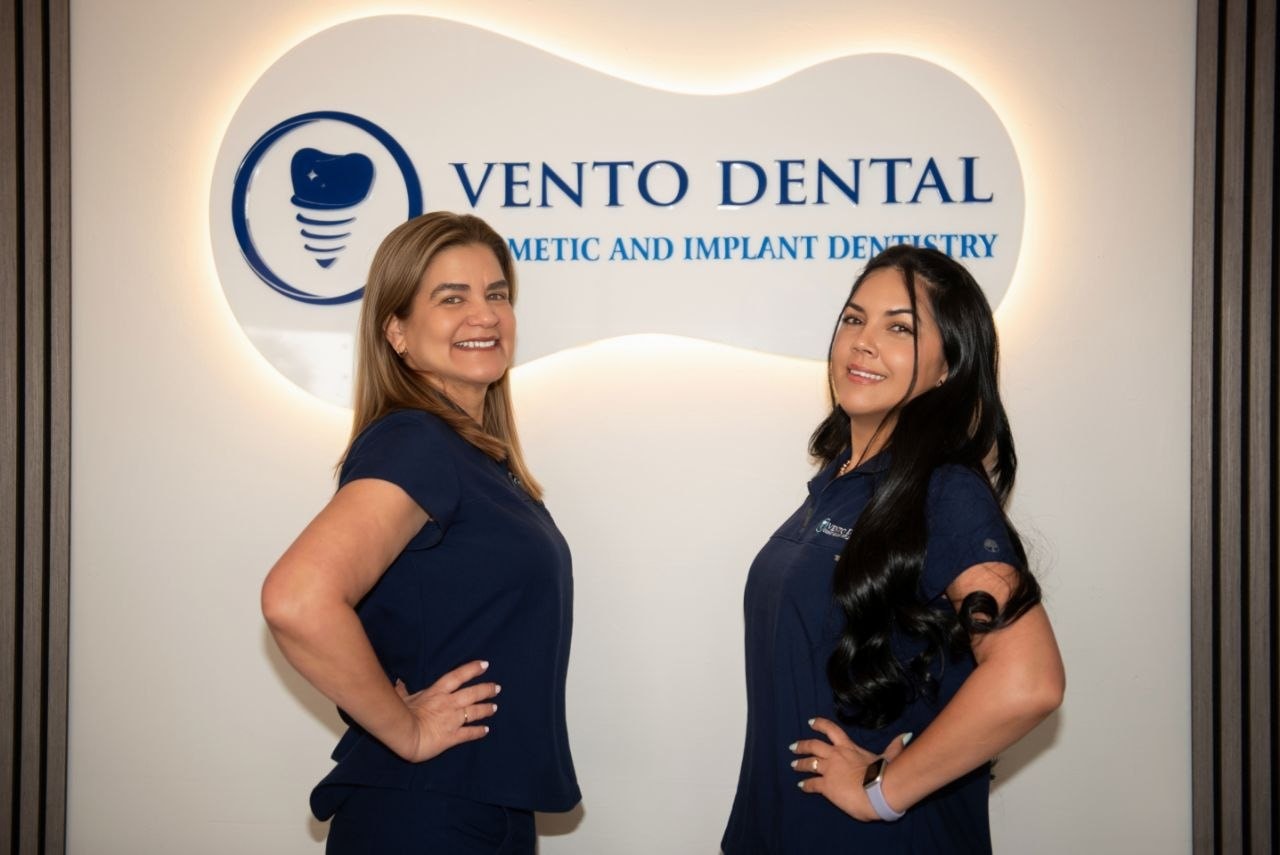 Vento Dental team in front of logo